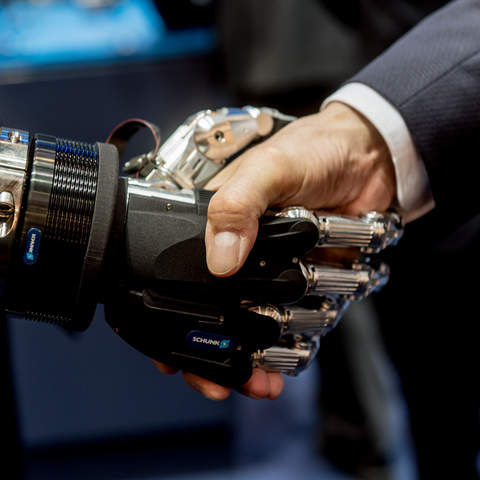 roboter and human shake hands